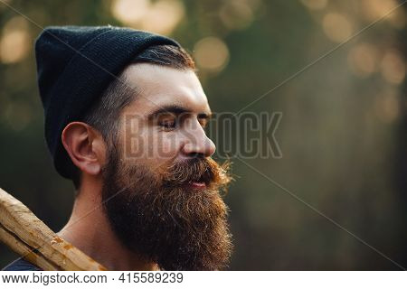 A Wet Bearded Man In A Dark Sleeveless T-shirt With A Large Mustache And Gray Hair Looks Up Into The
