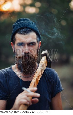 Old Bearded Stylish Man In A Dark Sleeveless T-shirt And In A Warm Hat With A Large Mustache And Gra