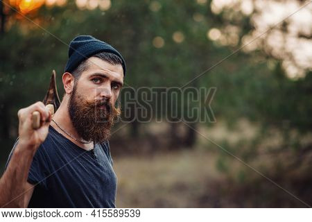 A Strong Muscular Man With A Thick Beard And A Large Mustache In A Dark Sleeveless T-shirt And A War