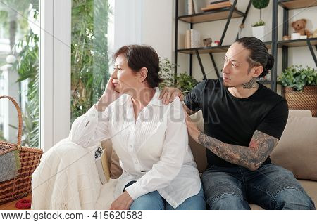 Adult Son Supporting And Reasurring His Sad Stressed Mature Mother