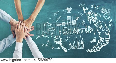 Business Idea Concept With Human Hands And Handwritten Sketch Of Startup Icons On Green Chalkboard B