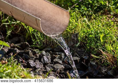 Clean Water Flows Through A Plastic Chute. Water For Watering Plants.