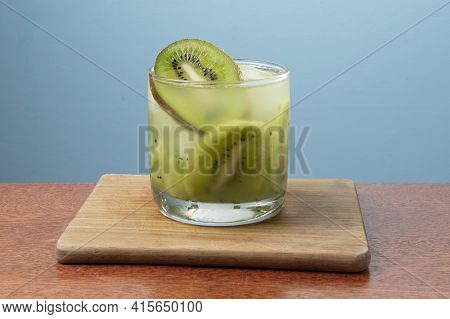 Alcoholic Drink Caipirinha Based On Kiwi And Aguardente Distilled Cocktail Drink And Fruits On Blue 