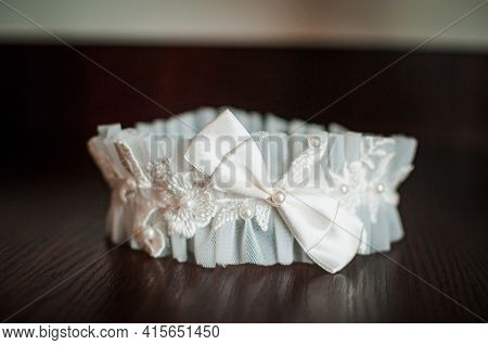 White Color Garter Lying On The Wooden Table