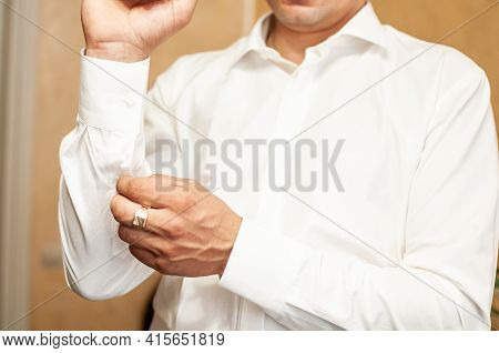 A Groom Fastening A Cuff-link On The Shirt