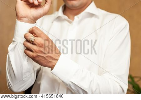 A Groom Fastening A Cuff-link On The Shirt