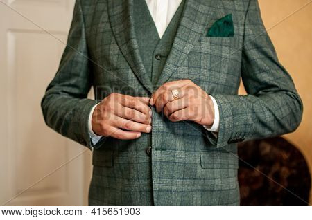 Groom Buckles The Button On His Jacket