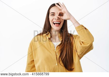 Happy Laughing Woman Show Ok Sign And Smiles, Make Okay Gesture Over Eye And Looking Through, Praise