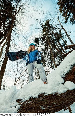 Beautiful Young Girl In A Blue Ski Suit And Helmet. On The Head Are Glasses For Snowboarding. Snow-c