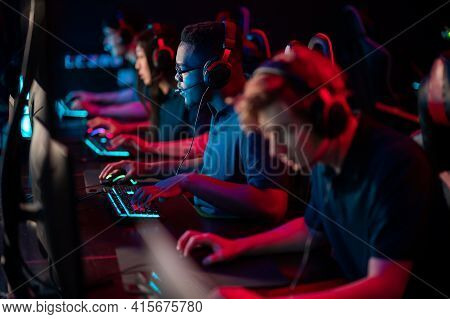 A Multi-racial Team Of Esports Athletes Conducts A Training Session Before An Online Shooter Tournam