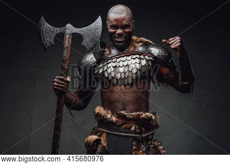 Rabid African Warrior In Steel Armor And Fur Wielding An Axe In Studio