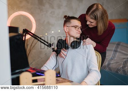 Beautiful Blod Hair Woman Hug His Husband During The Work On Computer. Happy Couple Working At Home.