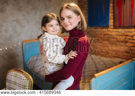 Adorable Little Girl Hug Her Beautiful And Young Godmother. Portrait Of Happy Woman Hug Her Goddaugh