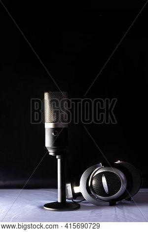 Professional Condenser Microphone And Headset On White Surface And Black Background, Low Key Portrai