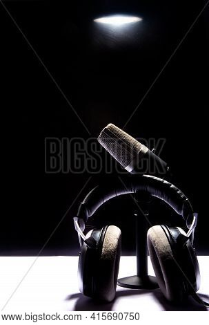 Professional Condenser Microphone And Headset On White Surface And Black Background, Low Key Portrai