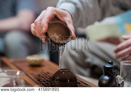 Stage Of Brewing Chinese Traditional Tea. Clay Cups On A Special Bamboo Board Gongfu Close-up With A