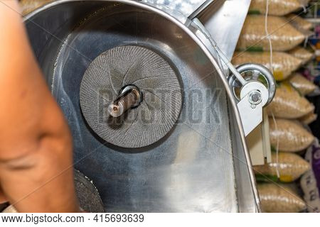 Man Turning His Back Preparing A Nixtamal Mill To Start Making Dough