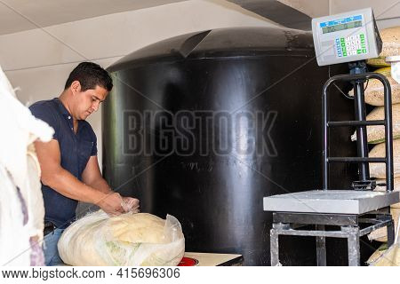 Man Packing Dough From A Typical Handle With A Plastic Sack