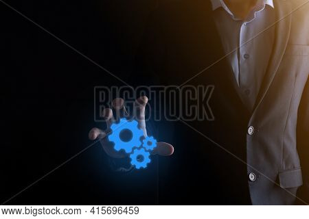 Business Man In Suit Holding Metal Gears And Cogwheels Mechanism Representing Interaction Teamwork C