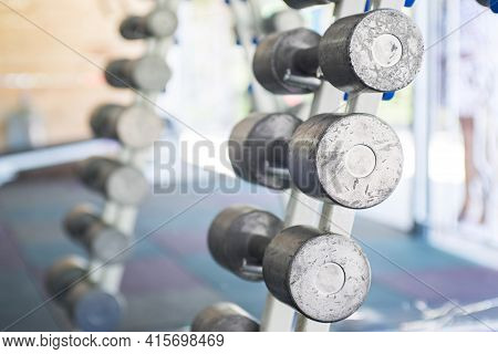Rows Of Dumbbells In The Gym. Sports Equipment In The Gym. Empty Gym During Quarantine.