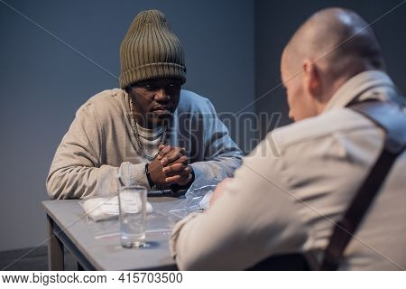 A Black Suspect In A Hat Under Interrogation At The Police Station Is Worried Invents An Alibi