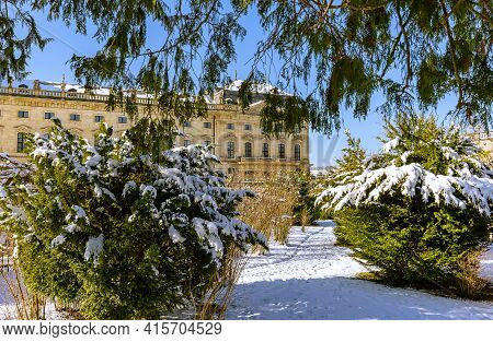 View Of The Schloss Wuerzburg Residenz Through Wintry Park, Wuerzburg Germany. Snow-covered Trees