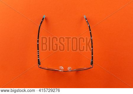 Eyeglasses On Orange Background, Myopia Or Presbyopia.  Eyesight Correction. Fashion Accessories.