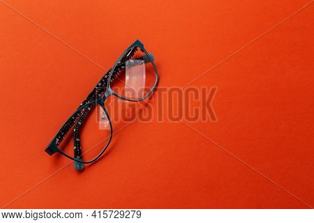 Eyeglasses On Orange Background, Myopia Or Presbyopia.  Eyesight Correction. Fashion Accessories.
