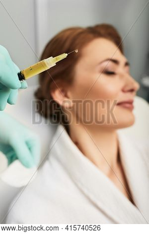 Syringe With A Patients Blood Plasma In A Cosmetologists Hand For A Plasmolifting Of A Womans Facial