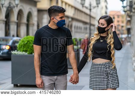 Couple In Love With A Mask Due To The Sars-cov2 Pandemic. Walking Down The Street