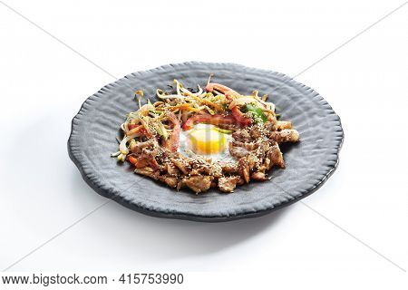 Teppan japanese cuisine - Teppanyaki Chicken with Egg and Vegetables. Sliced chicken breast on heat teppanyaki hot plate grill with sesame seed