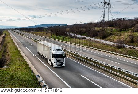 Big White Lorry Truck On A Rural Countryside Highway. Business Transportation And Trucking Industry