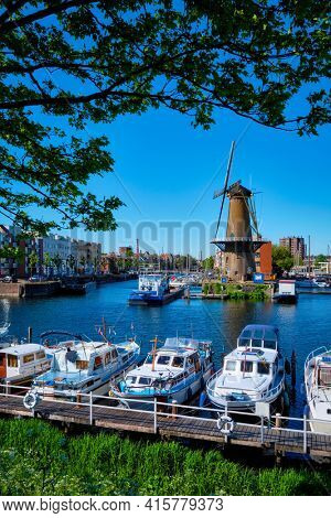 View of the harbour of Delfshaven and the old grain mill De Destilleerketel. Rotterdam, Netherlands