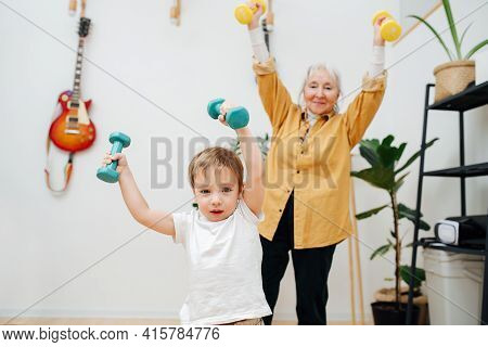 Euphoric Granny Doing Phisical Exercises With Her Grandson, Trying To Encourage Him To Stay Fit. The
