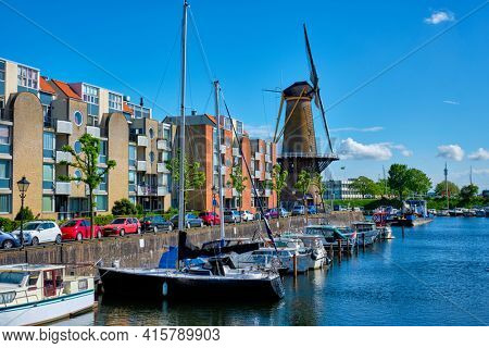 View of the harbour of Delfshaven and the old grain mill De Destilleerketel. Rotterdam, Netherlands