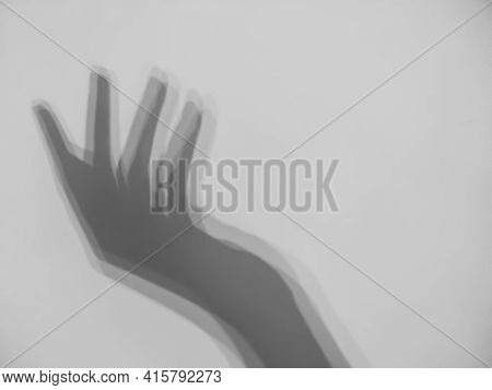 Shadow Of The Silhouette Of Female Hand On Gray Background. Elegant Female Hand Shadow With Copy Spa