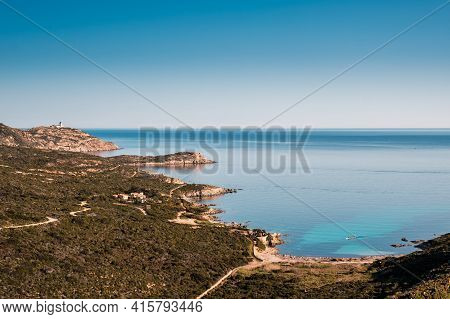 An Outrigger Canoe Sits In A Translucent Turquoise Bay Off The Coast Of La Revellata Near Calvi In T