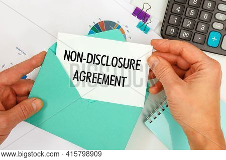 The Businessman Takes Out A Card From The Envelope With The Text Non-disclosure Agreement, On The Ba
