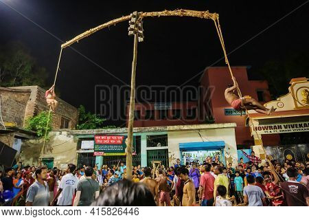 Howrah, West Bengal,india - 15th April 2019: Two Hindu Devotees Are Hanging From Pole In Air, At Nig