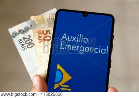 Minas Gerais, Brazil - April 6, 2021: Auxilio Emergencial In Mobile Phone Application And Money Bill
