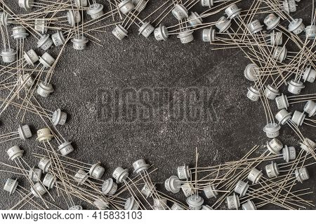 Old Many Soviet Transistors In Metal Case On Black Background With Copy Space For Your Text. Electro