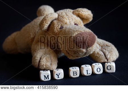 The Stuffed Plush Toy Is A Friendly Dog Next To My Blog Sign. The Concept Of A Blog Site For A Pet. 