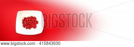 Krill Oil Capsules.banner. Red Gelatin Capsules With Krill Oil In A White Ceramic Cup On A Bright Re