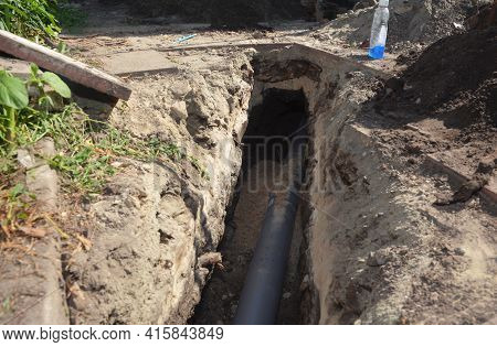 Installing Underground Downspout Drain Line, Sewer Line Or Waste Pipe In A Trench. Laying Pvc Pipeli