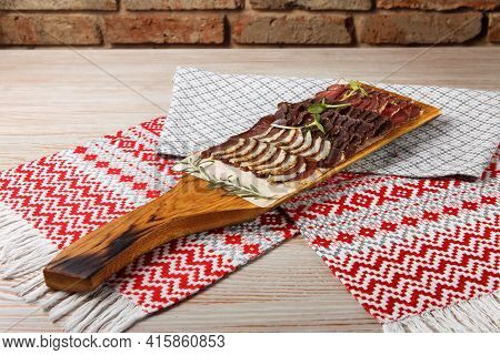 Set of chicken roll, pork meatloaf, beef, saltison and chicken pate on wooden tray in restaurant. Top view.