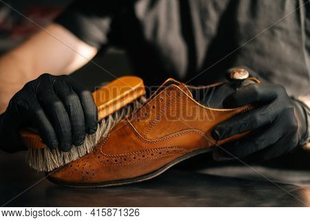 Close-up Hands Of Unrecognizable Shoemaker Cleaning With Brush Old Light Brown Leather Shoe. Concept