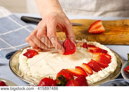 Woman Baker Stacks Strawberries On Meringue Strawberry Cake Base. Homemade Strawberries Cake Made Fr