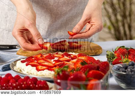 Woman Baker Stacks Strawberries On Meringue Strawberry Cake Base. Homemade Strawberries Cake Made Fr