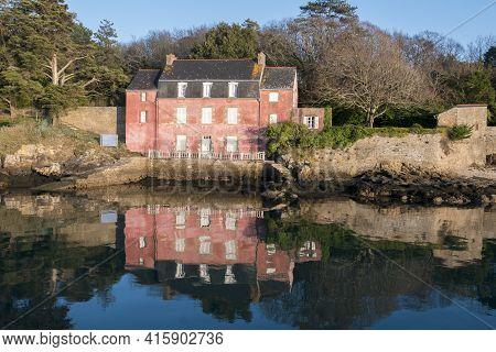 Sunny Day And Traditional Pink House On The Ile-aux-moines With Water Reflection In The Morbihan Gul