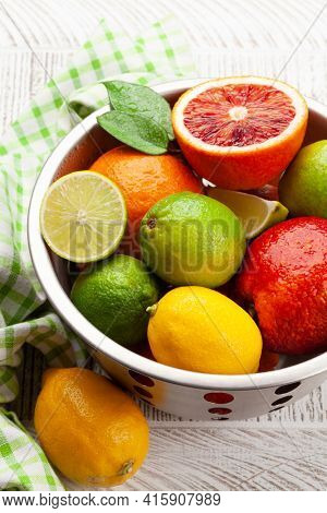 Various fresh citrus fruits in colander. Bood orange, lime, lemon